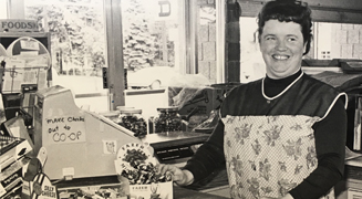 Women wearing apron standing in front of a cash register