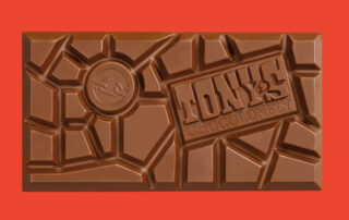 Close up of a Tony's Chocolonely bar on a red background