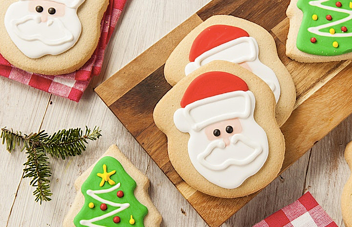 Holiday decorated cookies on table with greenery