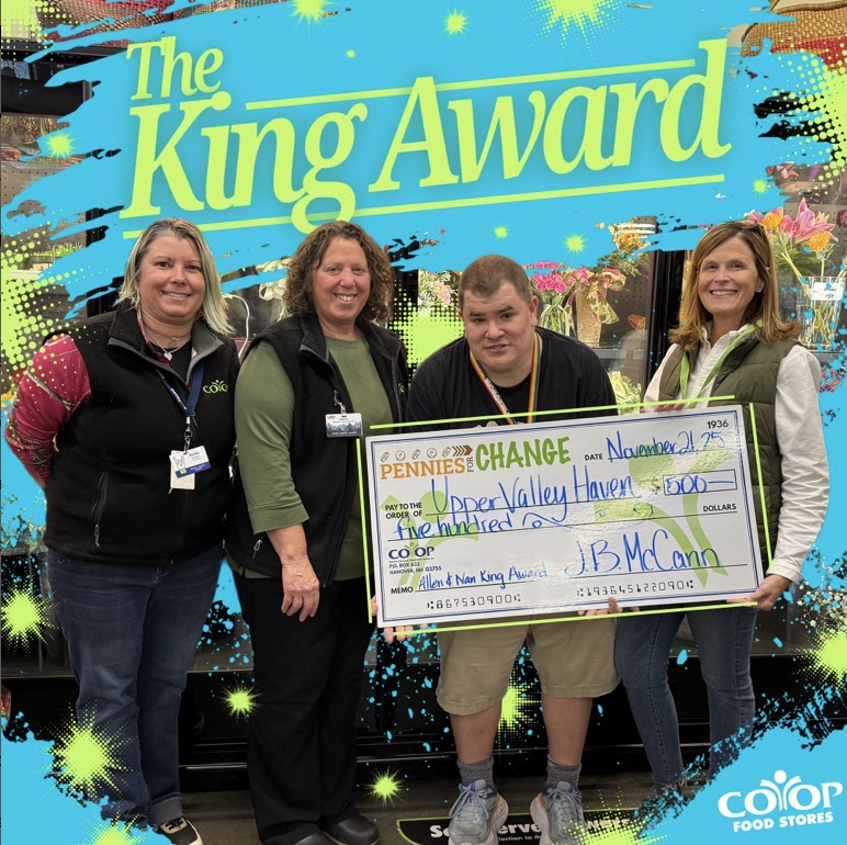 Several employees holding large check to Upper Valley Haven with words "the King Award" all on colorful background