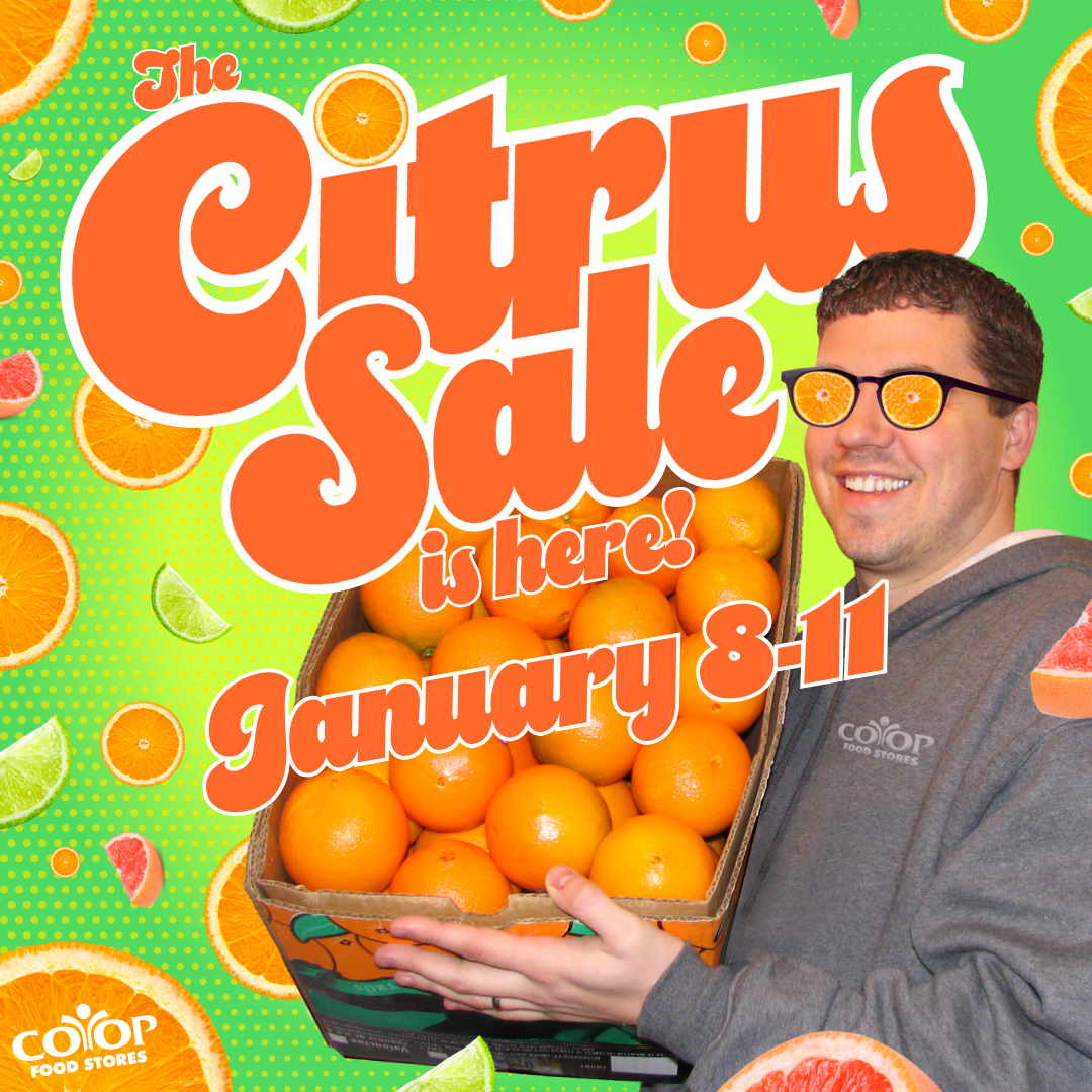 citrus_sale_here Co-op employee holding case of oranges on colorful background