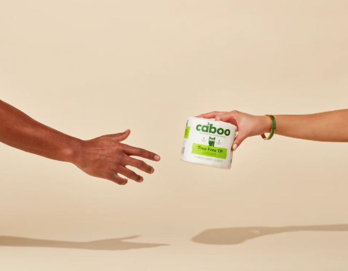 Illustration of one hand giving another a roll of Caboo toilet paper