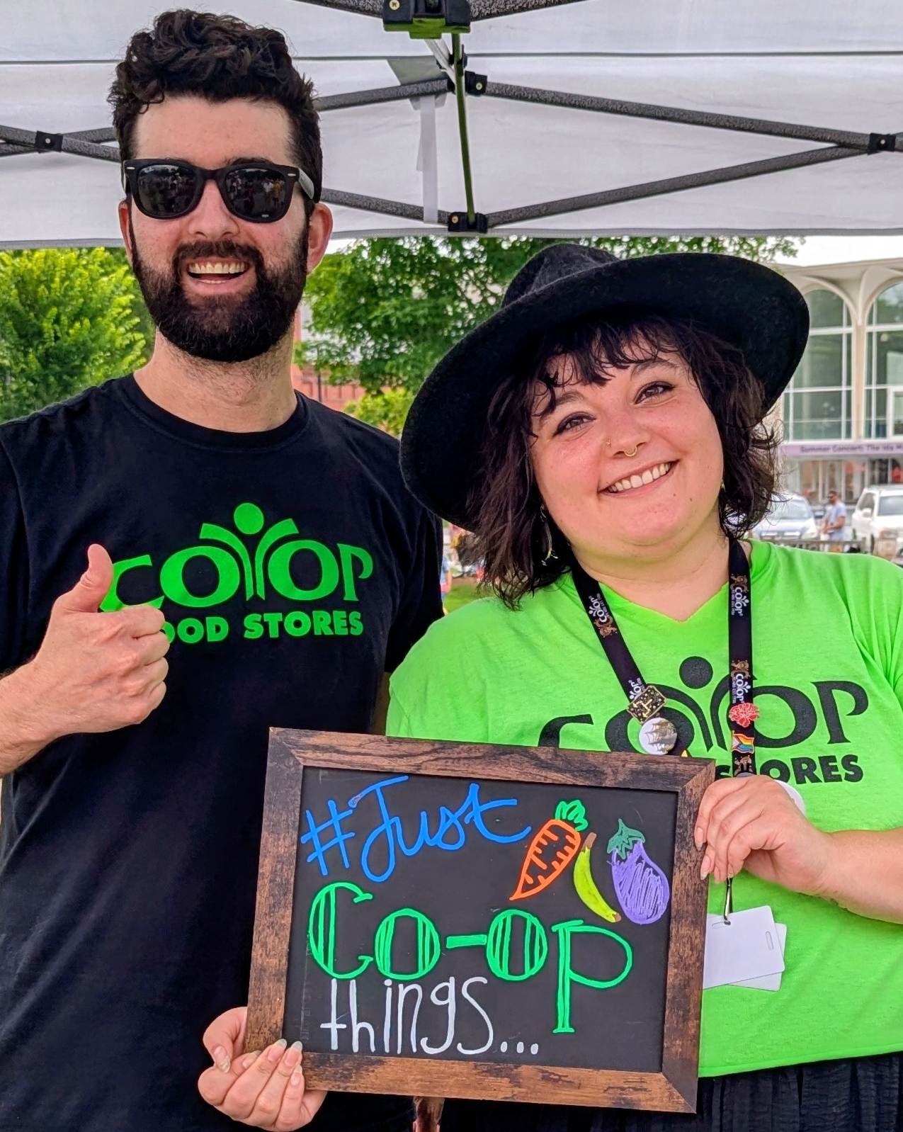 Two Co-op employees holding chalk sign with words #JustCo-opThings